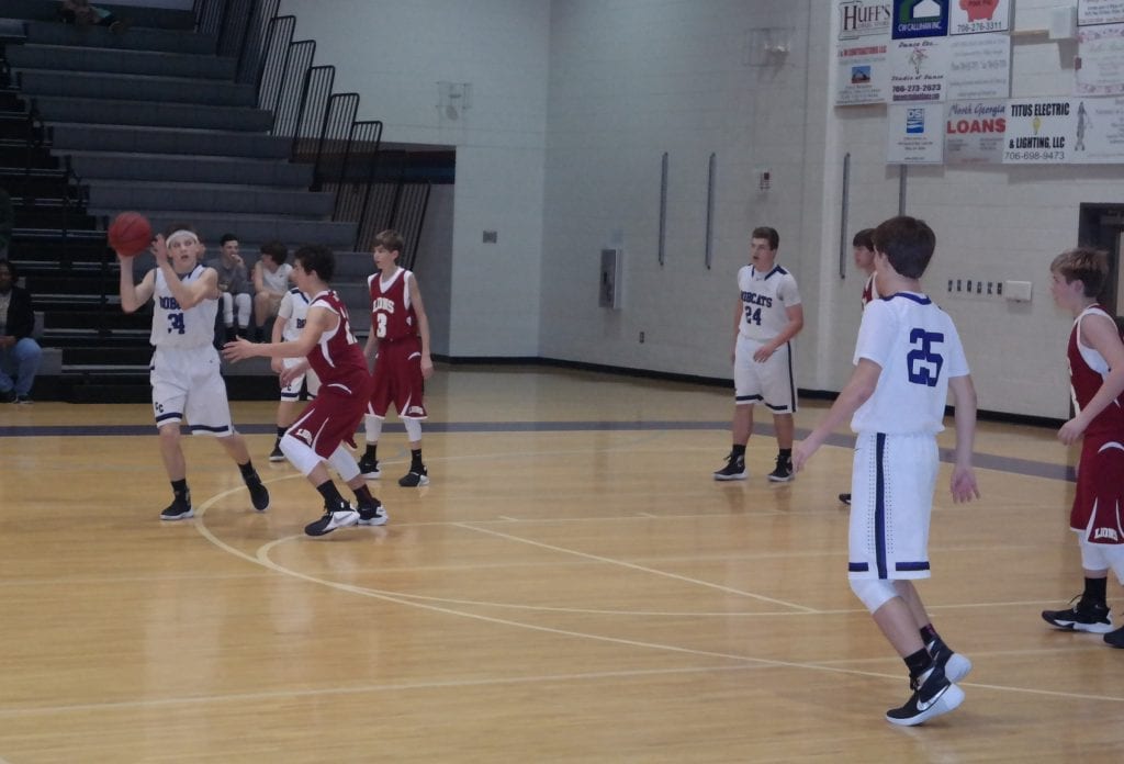 Clear Creek eighth-grader Connor Thompson looks to Alex Snelgrove (25) to complete a pass last Friday against Christian Heritage. He led the Bobcats with 17 points against the Lions. (Photo by: Kevin Hensley)