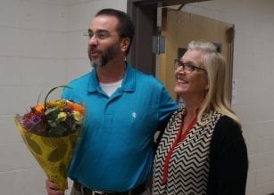 Principal Larry Walker offers flowers to Shannon Goble as he announces her as Teacher of the Year.